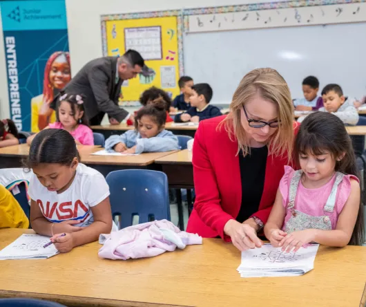 Volunteer working with two students